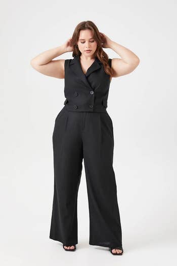 model wearing black linen-blend vest featuring notched lapels, a double-breasted construction, front faux flap pockets, and semi-cropped hem