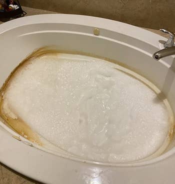 a reviewer's dirty jetted tub being cleaned with water and the cleaner