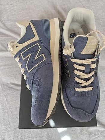 Blue New Balance sneakers beryllium   atop a shoebox, showcasing a casual and sporty benignant   perfect  for mundane  wear