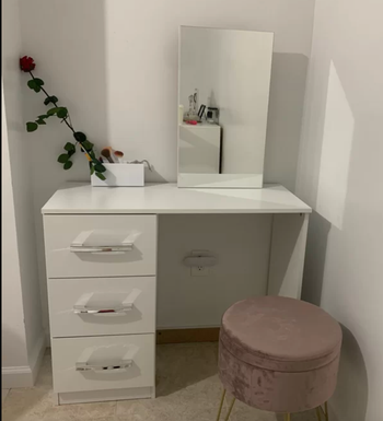 reviewer photo of the vanity with pink stool and rose