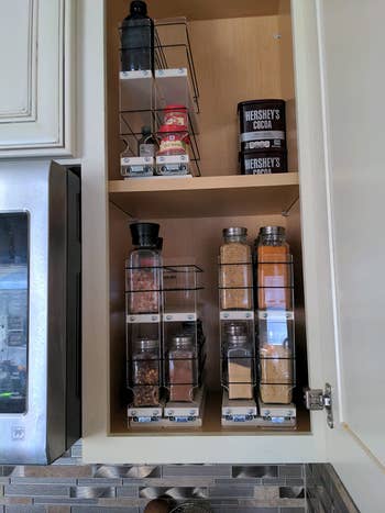 reviewer showing inside a narrow cabinet that has the vertical spice racks installed