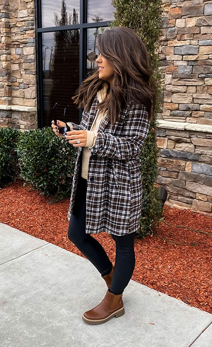 reviewer wearing brown and black blazer with boots and a hoodie underneath