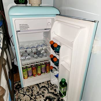 reviewer pic of same mini fridge opened with multiple shelves storing drinks
