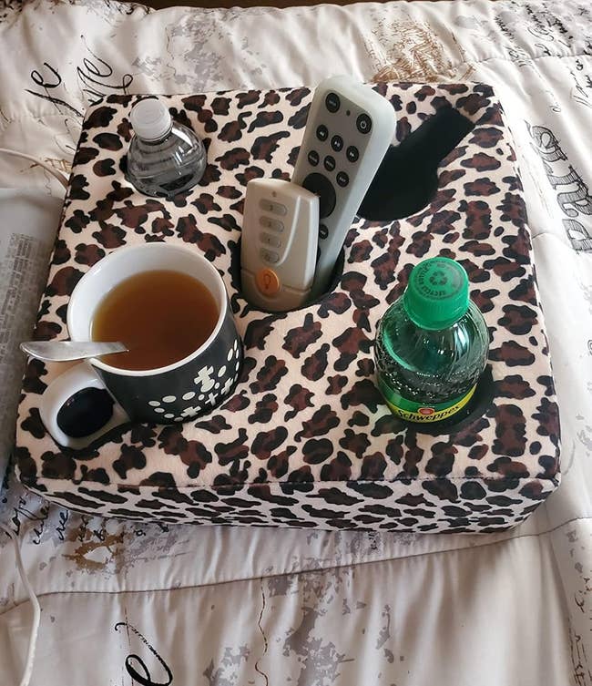 Leopard people thigh tray holding a distant control, cupful of tea, and 2 h2o bottles, perfect for cozy furniture oregon sofa lounging