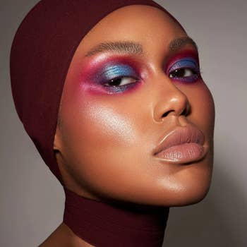 model wearing blue, pink, and purple pigment on their eyelids