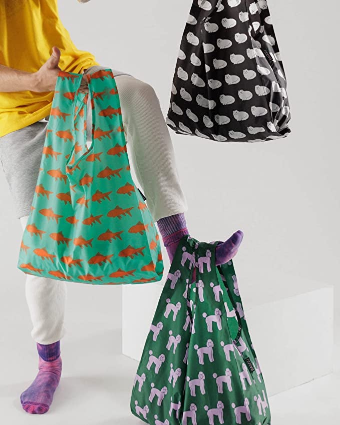 person's hand and legs holding baggu bags with pet designs on each