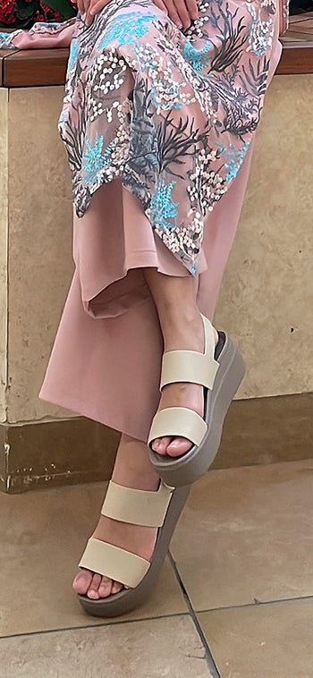 reviewer wearing the white crocs platforms with a skirt