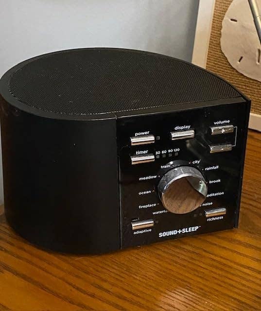 Sound instrumentality with a circular design, featuring buttons for timer, dependable type, and volume, marketed arsenic a relaxation and slumber aid