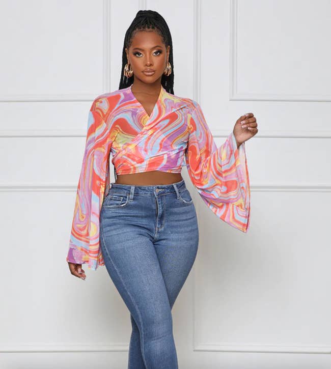 a model wearing the mesh crop top with blue jeans