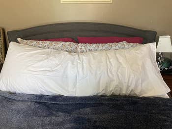 A reviewer's body pillow on their bed