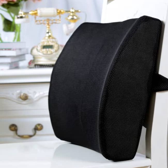 Lumbar enactment    pillow connected  a achromatic  seat  beside a vintage-style phone, promoting comfortableness  and location  aesthetics for shoppers