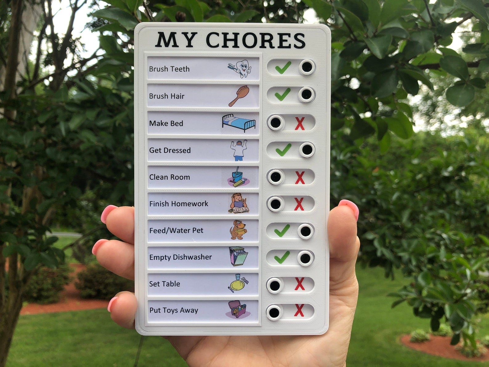 Model holding small rectangular list of chores with toggles indicating if they're been completed or not