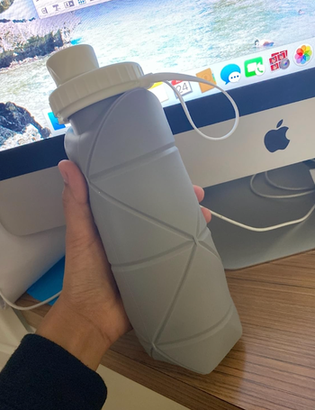Reviewer holding gray water bottle with geometric indents 