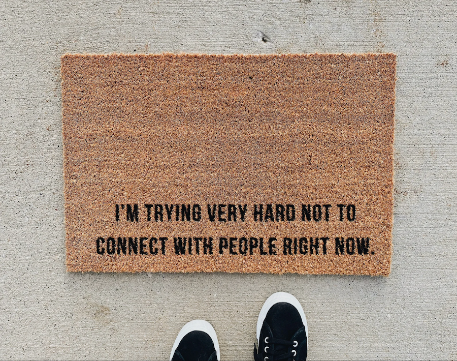 Model standing in front of brown doormat that reads