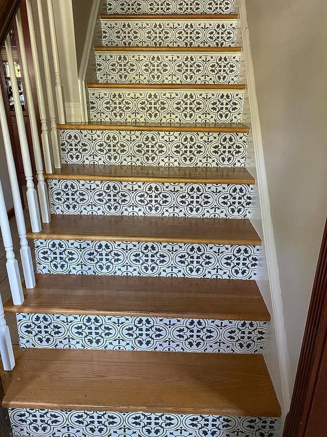 reviewer image of the clover design peel and stick decals on an indoor staircase