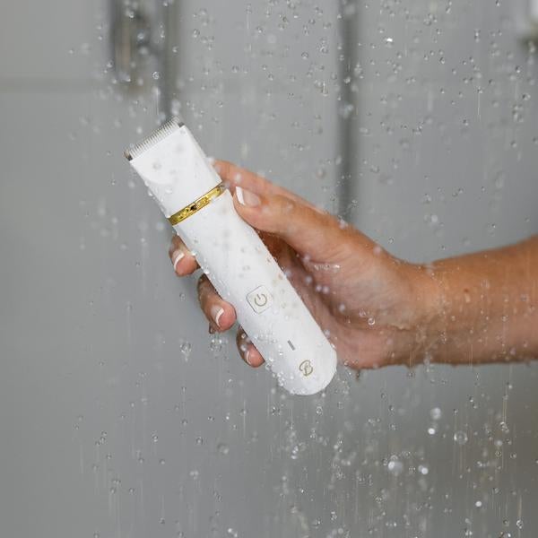 Model holding white trimmer in shower