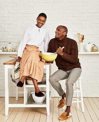 couple in kitchen with one partner wearing the slippers