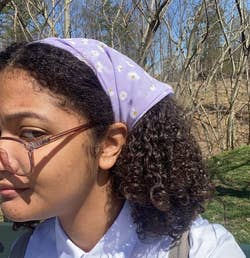reviewer wearing the purple daisy-patterned headband-scarf