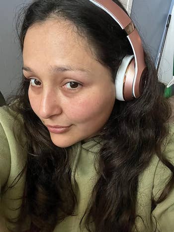reviewer wearing the pink headphones