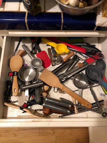 a reviewer's drawer with utensils chaotically throughout