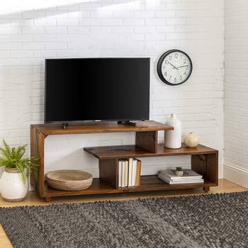the wooden console holding a tv and other decorative items
