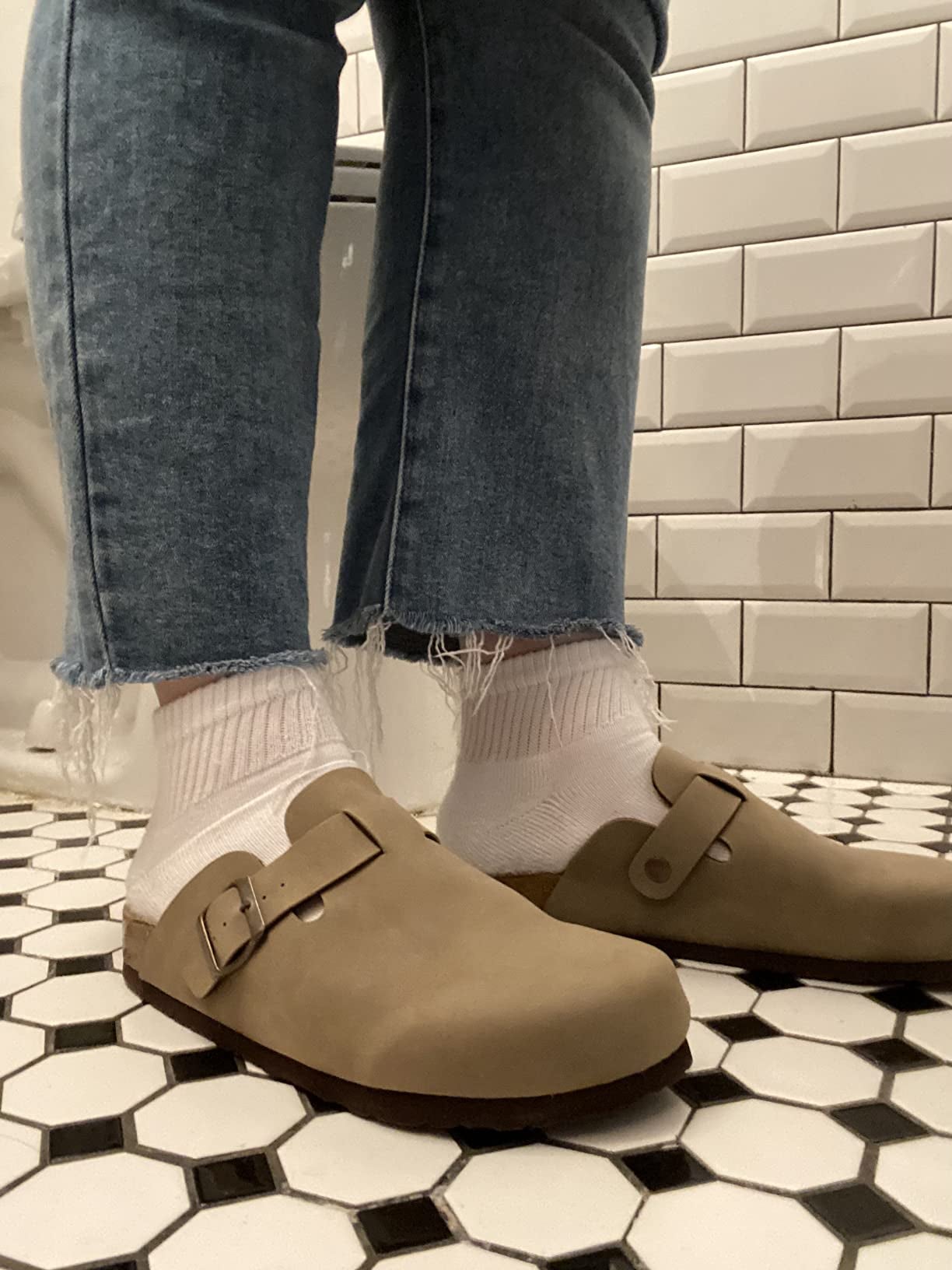 a reviewer wearing the brown sandals with socks