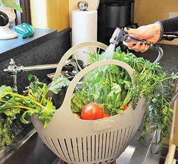 A model washing veggies in the colander in a sink