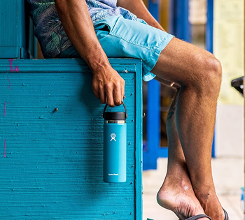 model holding the blue tumbler by its handle