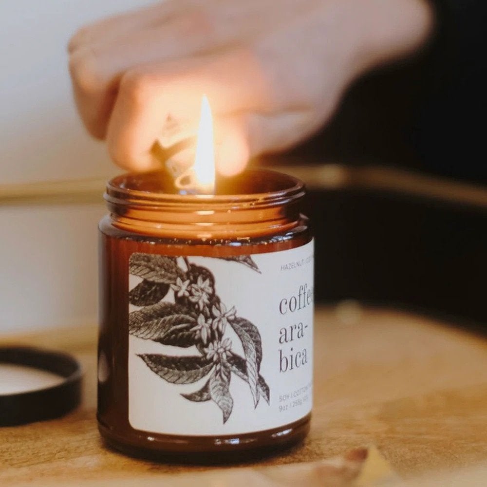 coffee candle in amber jar being lit