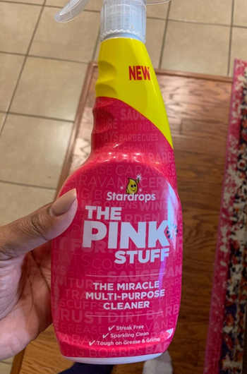 Reviewer holding a pink spray bottle 