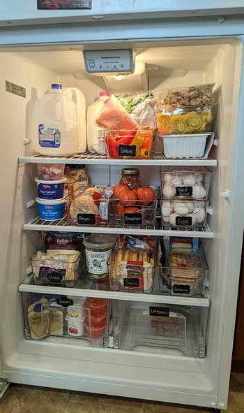 another reviewer's fridge organized using the bins, which they've labeled