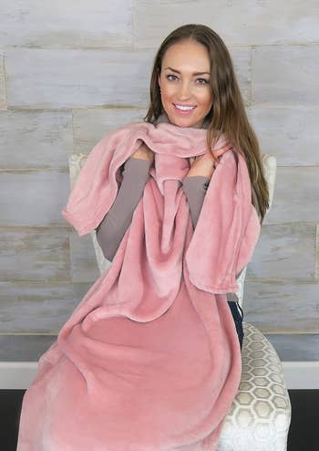 model holding the fluffy pink blanket inside the pouch