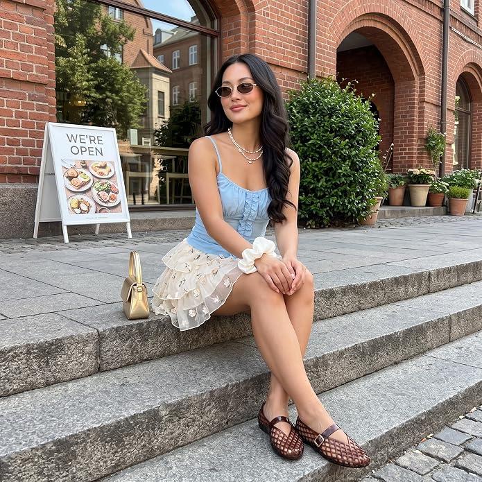 A pistillate   sits connected  a chromatic  ledge successful  stylish summertime  clothing, featuring a bluish  apical  and a polka dot skirt, wearing sunglasses