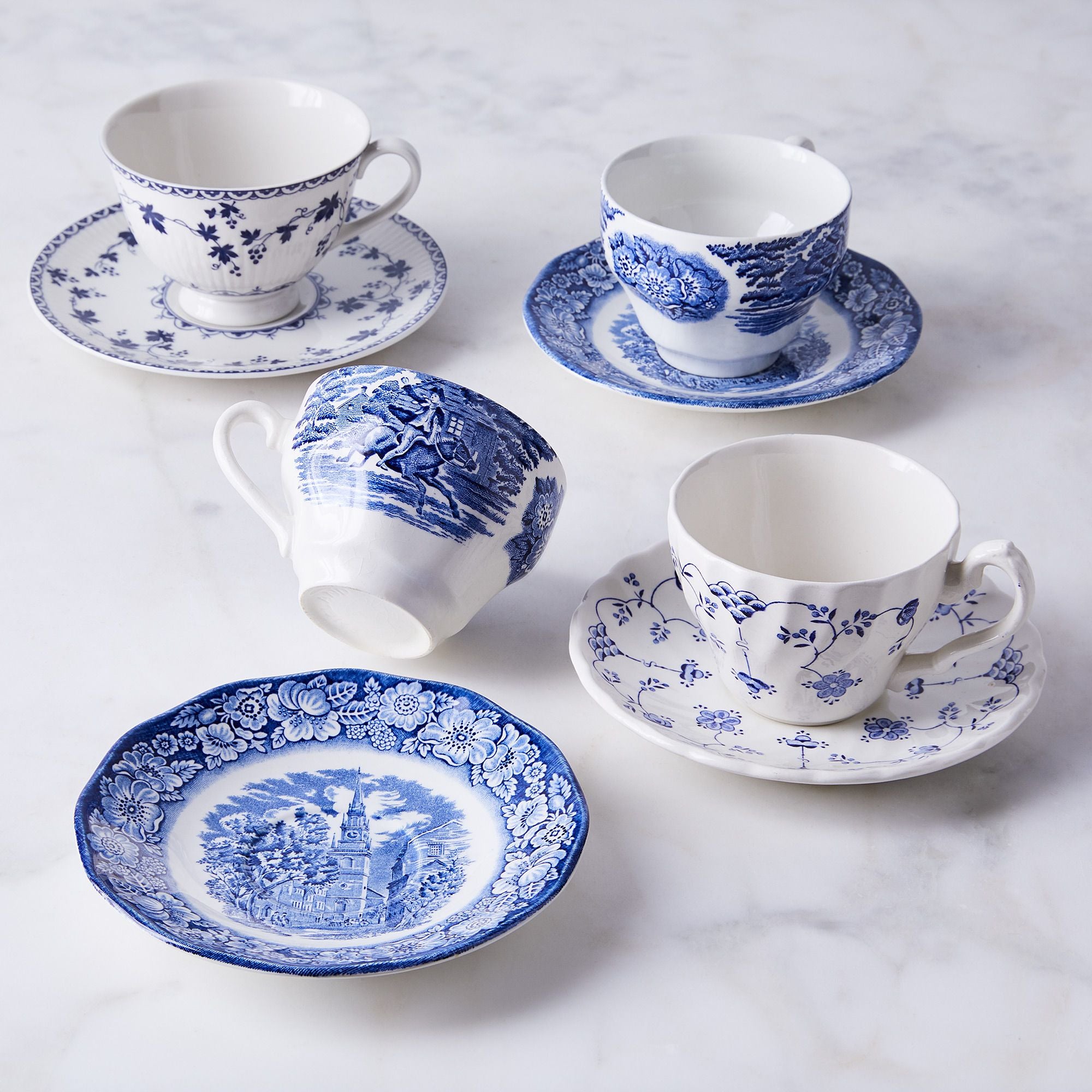 four blue and white teacups and saucers