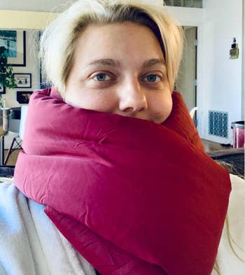 Reviewer wearing magenta scarf-like pillow around their neck 