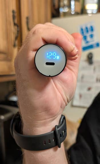 Close-up of a manus holding a tiny integer standard displaying