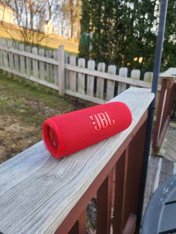 JBL portable talker  connected  a woody  railing successful  an outdoor setting