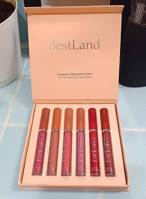 Six BestLand matte lipsticks in a box, with varying shades, displayed on a counter
