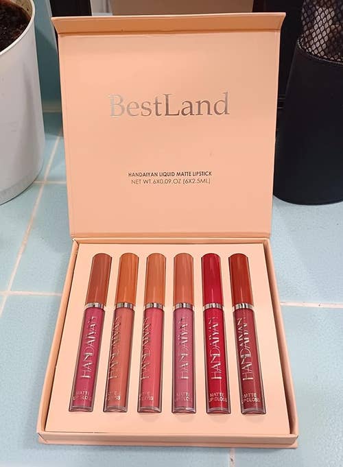 Six BestLand matte lipsticks in a box, with varying shades, displayed on a counter