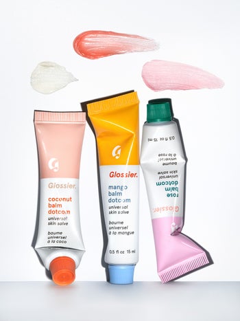 three tubes of the skin salve in coconut, mango, and rose with swatches above them