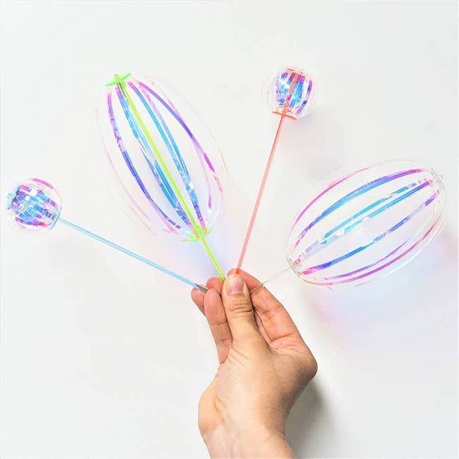 The twirler sticks with iridescent ribbons attached that make different round shapes