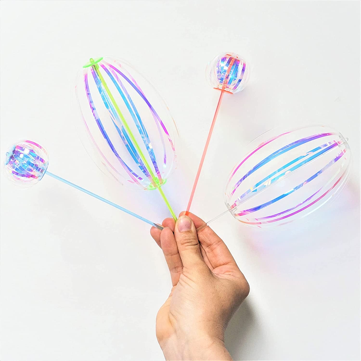 The twirler sticks with iridescent ribbons attached that make different round shapes