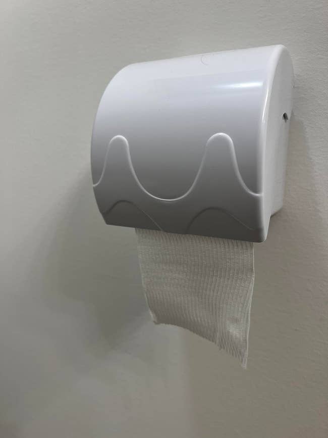 Toilet insubstantial dispenser with a azygous expanse of insubstantial disposable against a plain wall