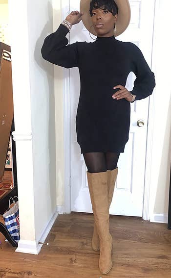reviewer wearing the black dress with tights and tan boots