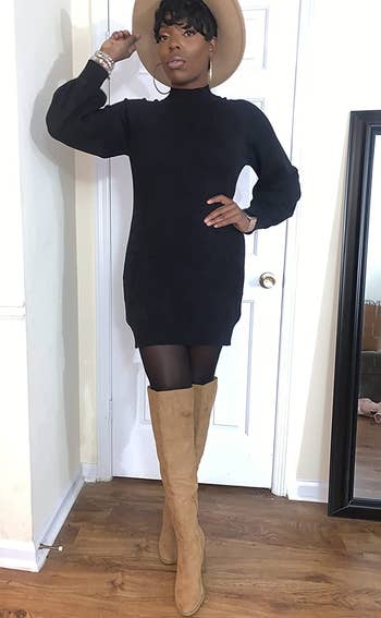 reviewer wearing the black dress with tights and tan boots