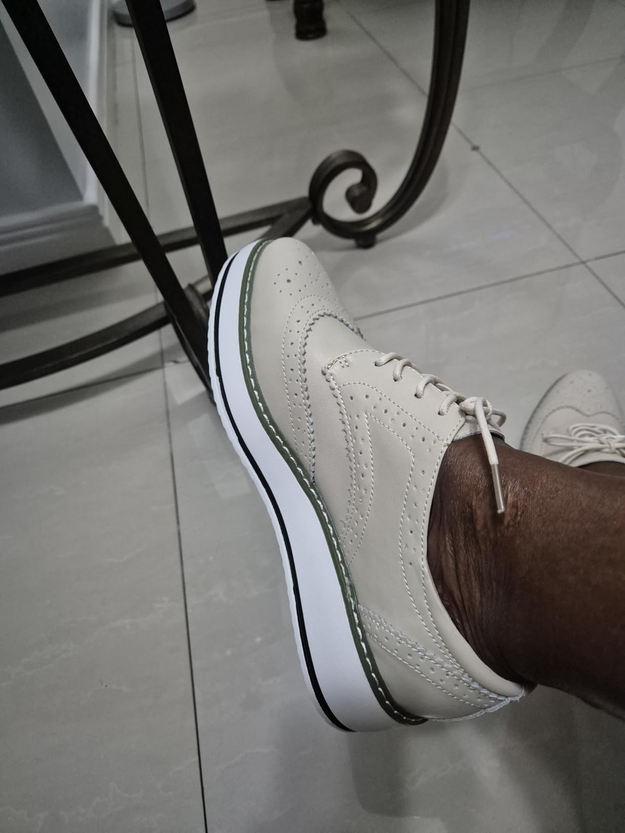 Person wearing stylish level    oxford shoes with elaborate  stitching