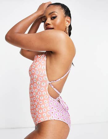 model shown from side in suit with front and back in same floral print but one peach and one pink