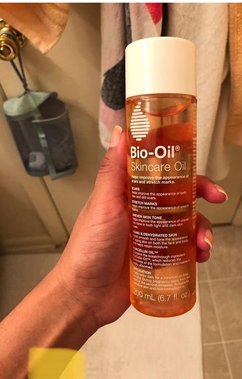 reviewer holding bottle of bio-oil in hand