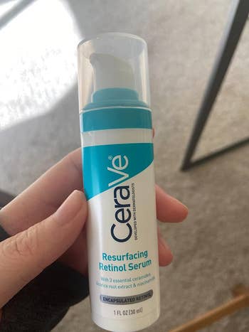 reviewer photo of them holding the blue and white serum bottle