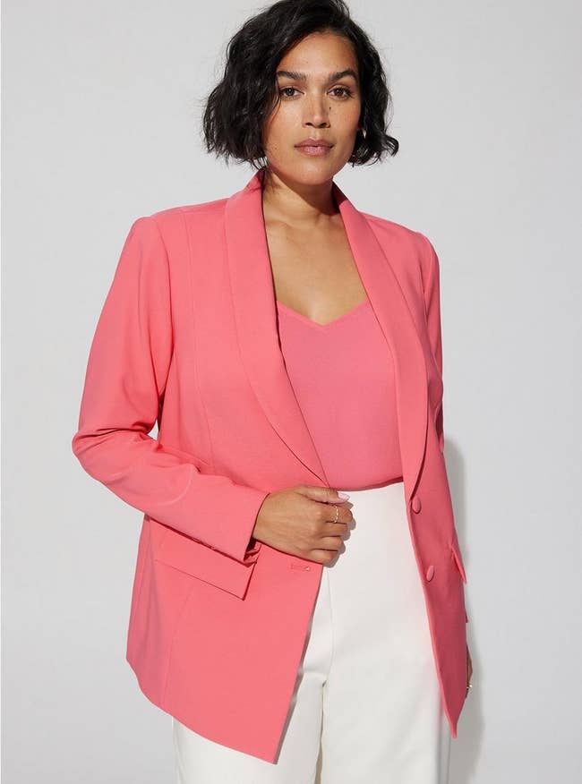 Model in bright pink button up blazer with pockets 